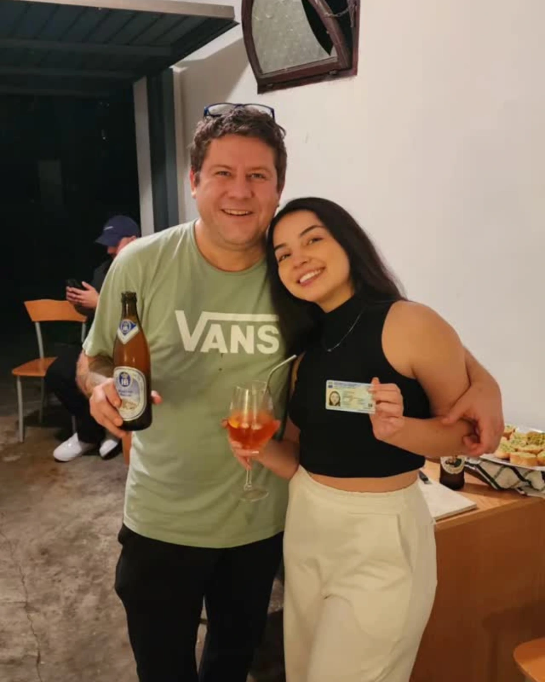 Pareja de clientes de Speranza abrazados, ella con el documento de identidad italiano