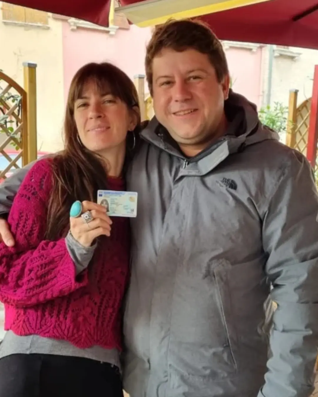 Pareja de clientes de Speranza posando al aire libre, con el documento de identidad italiano