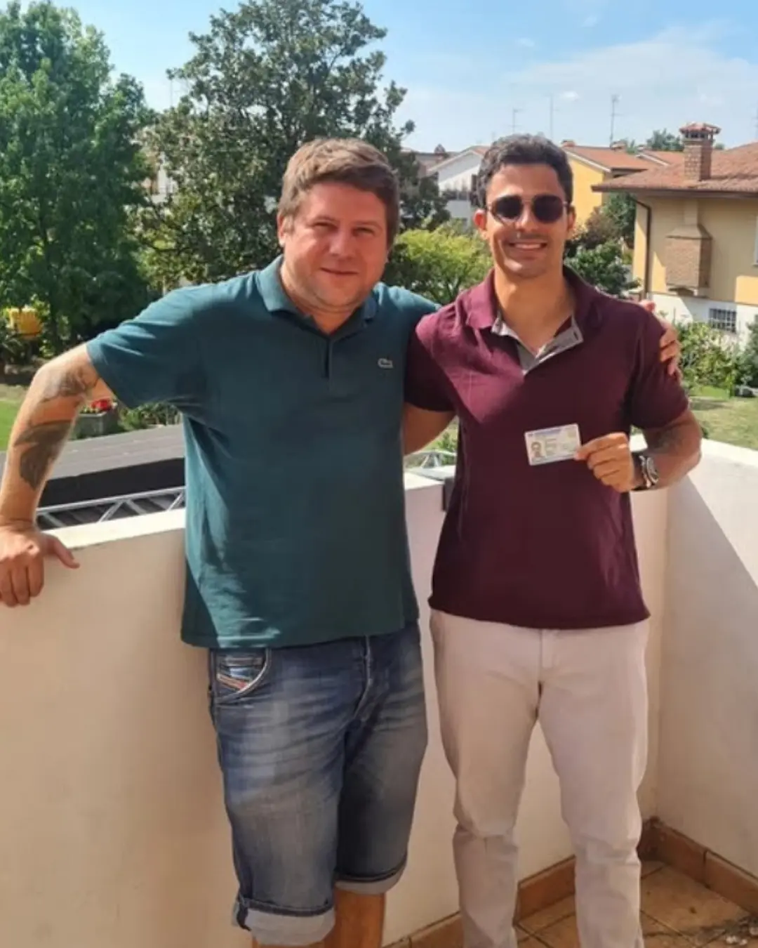 Dos clientes de Speranza en un balcón, uno con el documento de identidad italiano