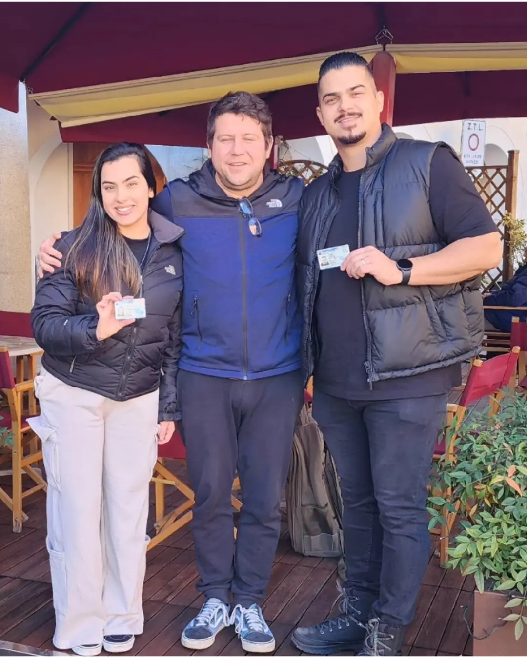 Tres clientes de Speranza posando juntos, con los documentos de identidad italianos