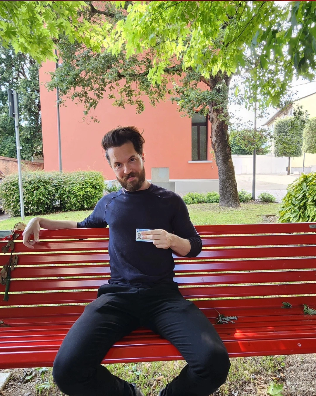Cliente de Speranza sentado en un banco en Italia, con el documento de identidad